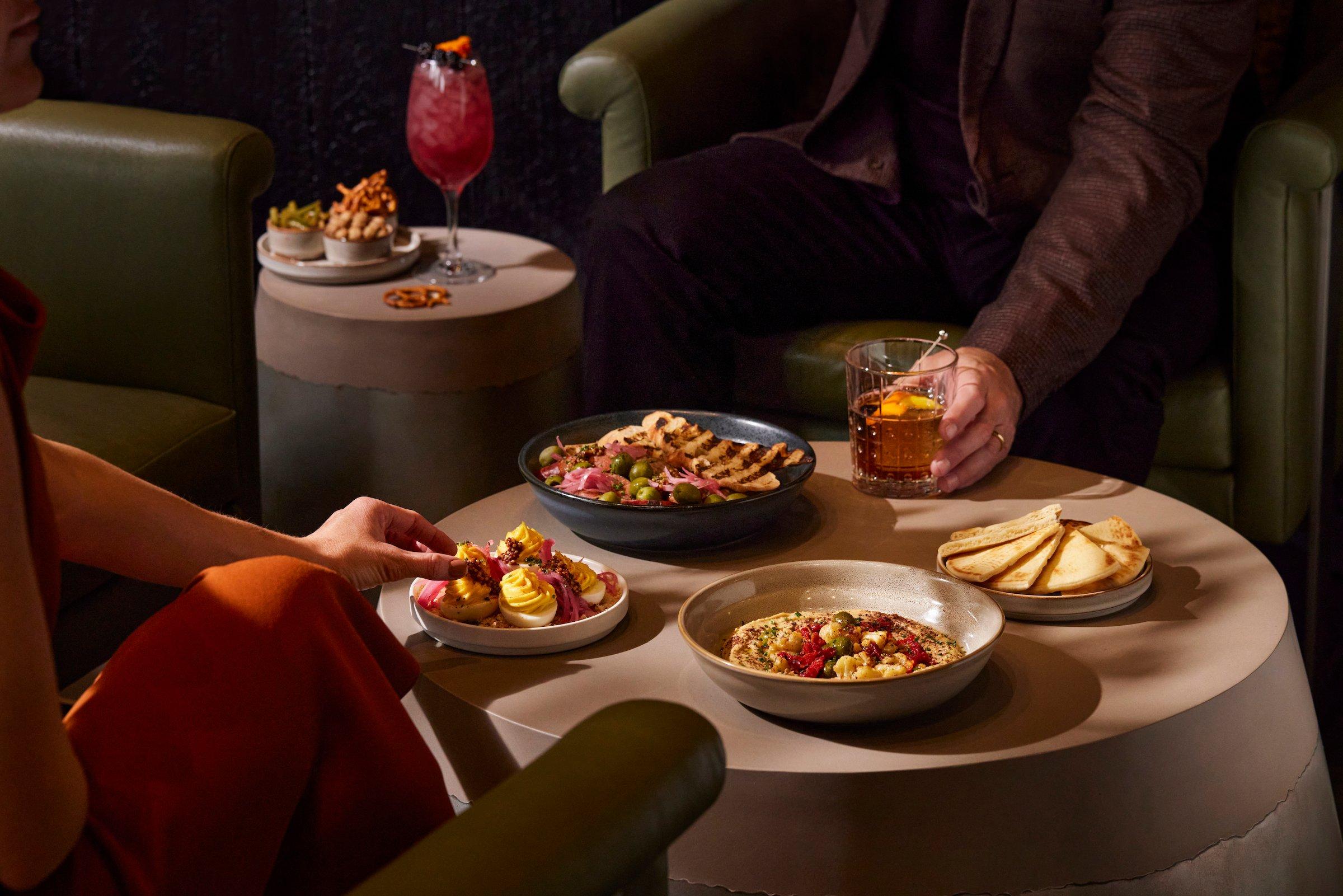 Two people with several dishes at Flo restaurant at Black Desert Resort