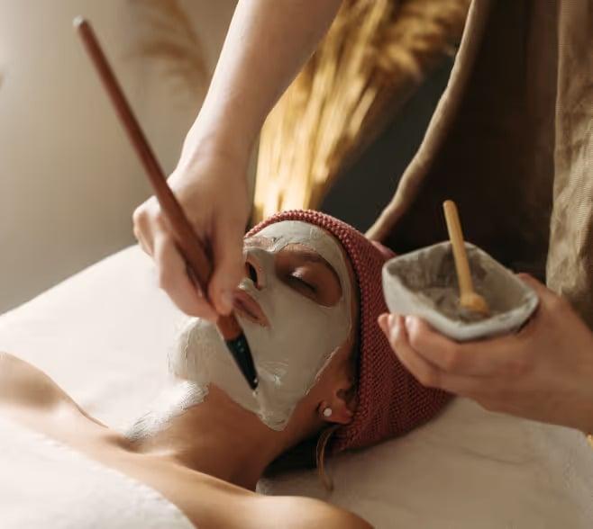 A woman getting a clay mask applied to her face at the spa at Black Desert Resort