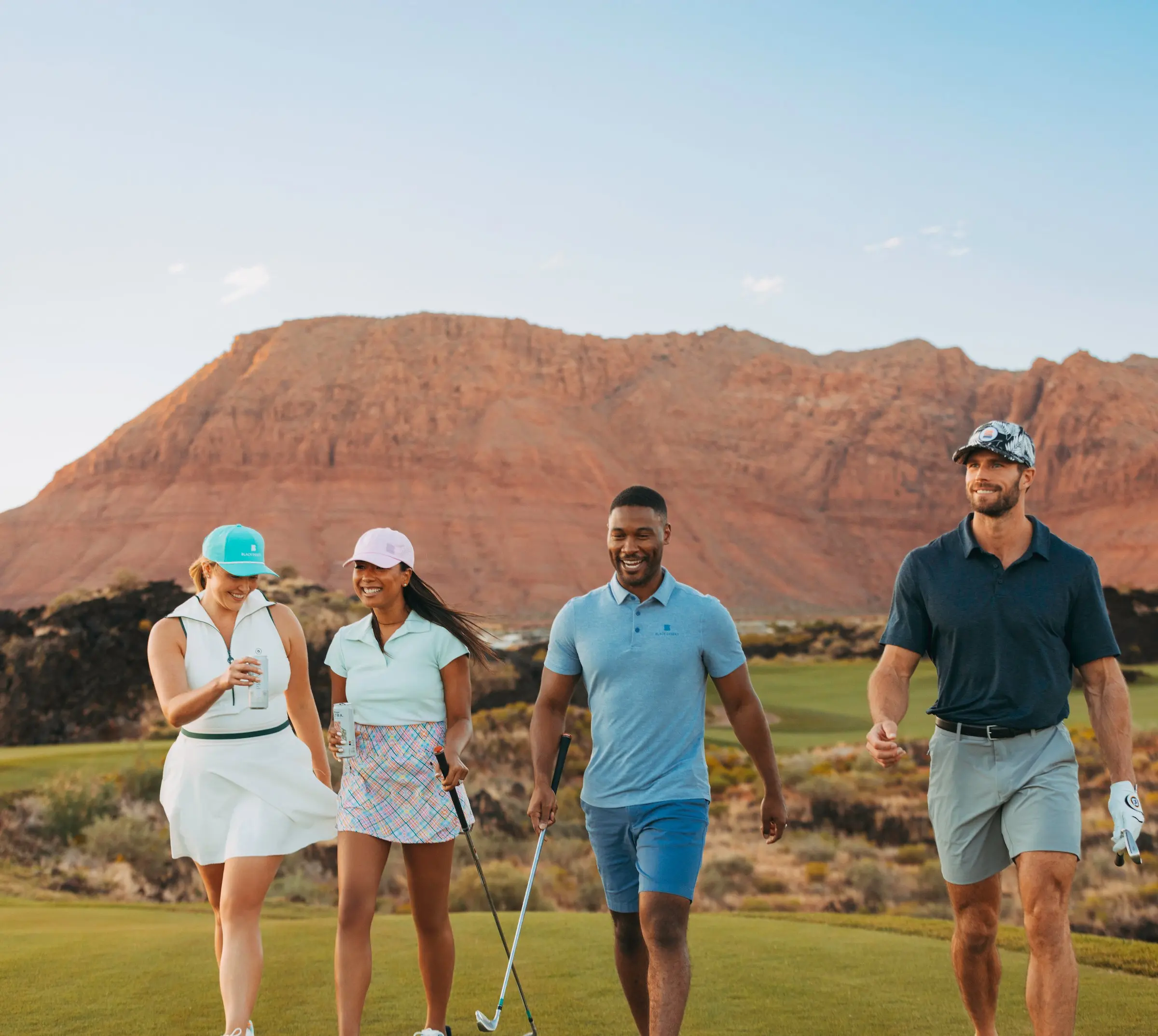 A group of four people walking on the golf course at Black Desert Resort