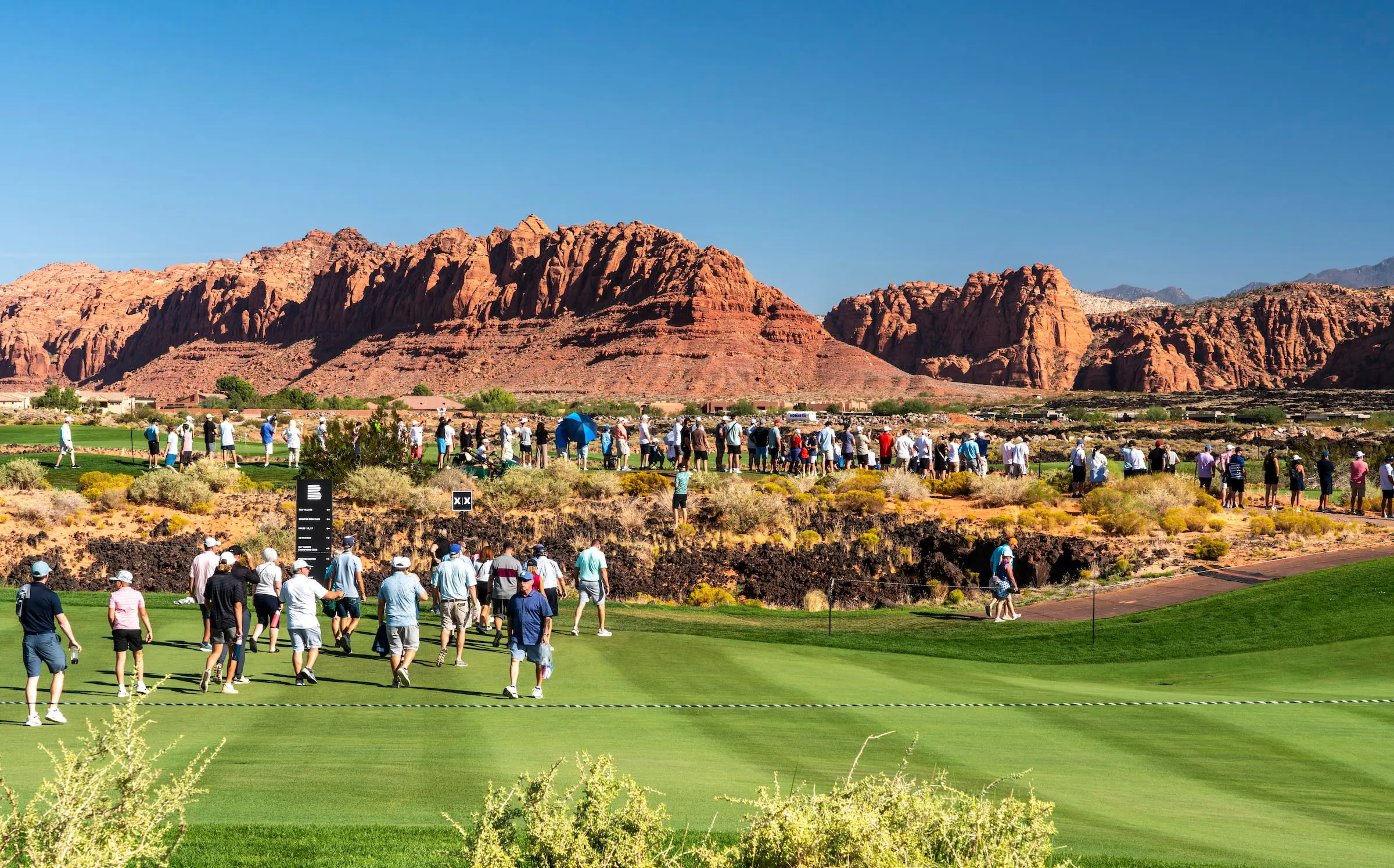 A large gallery of spectators watches a professional golf tournament at Black Desert Resort, home to a championship course on the PGA and LPGA Tours.
