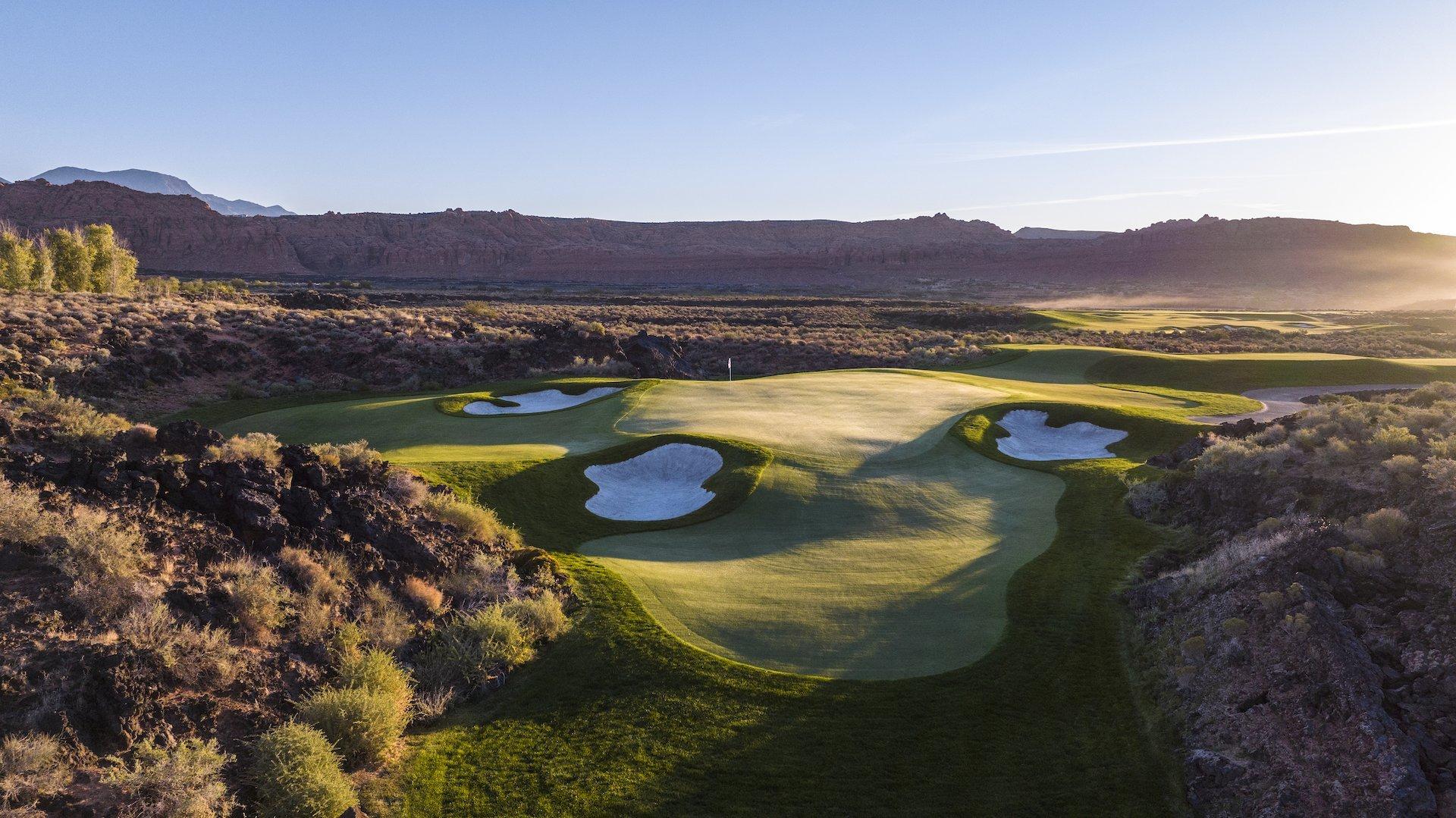 The stunning golf course at Black Desert Resort, where a lush putting green and white sand traps are carved directly into ancient black lava fields.