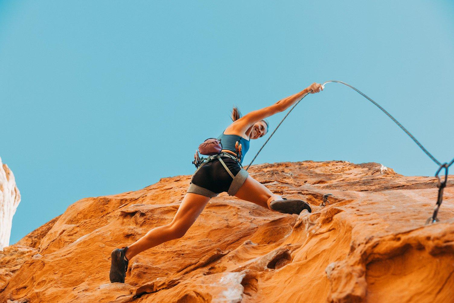 Woman Rapelling down red rock